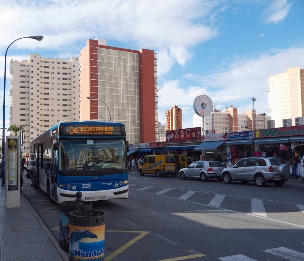 A bus pulling out of a stop while surrounding cars make room