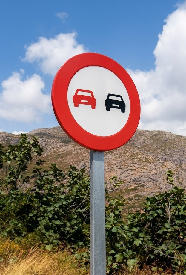 Road diagram marking where overtaking is banned: curves, crests, pedestrian crossings, intersections and tunnels