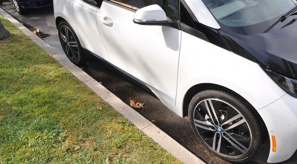 A car pulled over briefly at the kerb with hazard lights on and the driver still inside