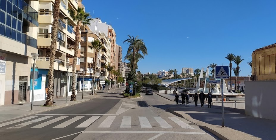 A driver approaching a pedestrian crossing with people waiting